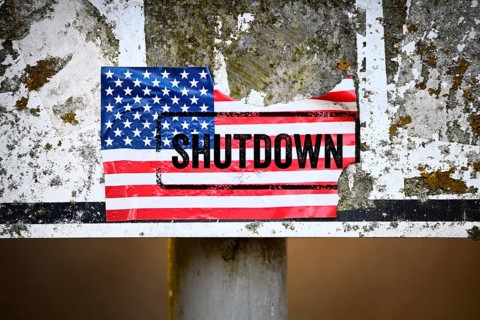 Torn sticker of US flag with shutdown printed on it, photomontage