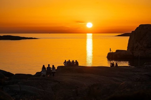 Silhouettes of tourists, sun melting in the sea, sunset, archipelago landscape, Smögen,