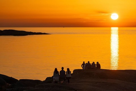 Silhouettes of tourists, sun melting in the sea, sunset, archipelago landscape, Smögen,