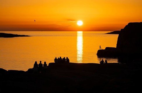 Silhouettes of tourists, sun melting in the sea, sunset, archipelago landscape, Smögen,