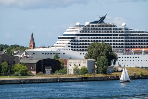 Large cruise ship MSC Poesia in the harbour, church tower in the background, Warnemünde, Rostock,
