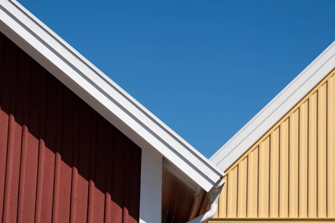 Red and yellow house gables bordering each other, blue sky, Fjällbacka, Bohuslän, West Sweden,