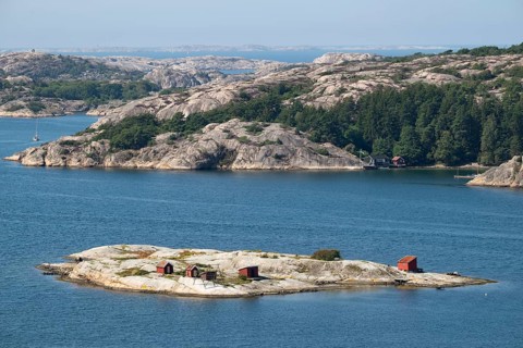 Archipelago landscape with rocks and an offshore archipelago island with falun red woodsheds,