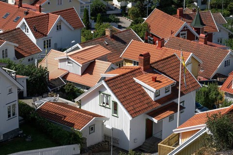 Bird's eye view of traditional, white Scandinavian wooden houses with orange-red roofs, Fjällbacka,