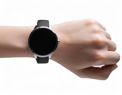Close-up of a person's wrist wearing a sleek smartwatch with a black strap and blank screen,