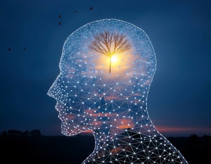 A creative representation of a human head silhouette incorporating an illuminated brain. The image
