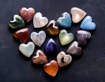 An artistic arrangement showcasing a variety of heart-shaped gemstones with vivid colors placed on