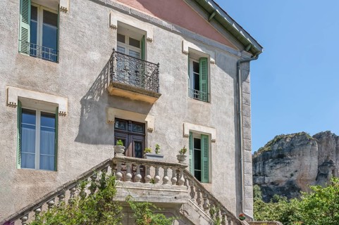 Typical Midi village architecture with stone balustrade and wrought-iron balcony of a light grey