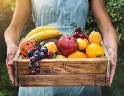 HHands hold a wooden box with fruits. Purchase and delivery of fresh fruit, AI generated