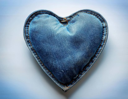 A beautiful heart-shaped denim pillow, symbolizing love and creativity, designed from repurposed