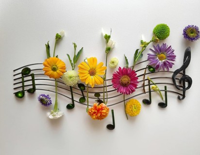 Floral arrangement creatively mimicking sheet music, blending vibrant flowers and artistic design