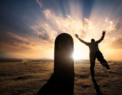 A silhouette of a lone figure walking off a gravestone, The scene evokes Resurrection thoughts