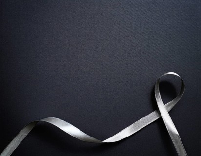 A beautifully wrapped gift box adorned with colorful satin ribbons forming a bow, contrasting