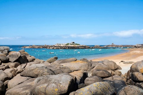 The wide bay of Tregastel on the Cote de Granit Rose shows the turquoise blue sea with white