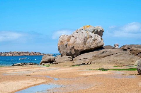 Spectacular pink granite rocks, sculpted by wind and sea, pile up on the beach of the Cote de