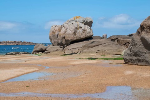 Spectacular pink granite rocks, sculpted by wind and sea, pile up on the beach of the Cote de