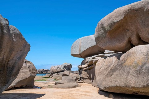 Spectacular pink granite rocks, sculpted by wind and sea, pile up on the beach of the Cote de