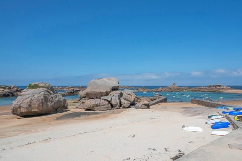 On the harbour beach of Trégastel on the Côte de Granit Rose, small boats lie on the light sand at