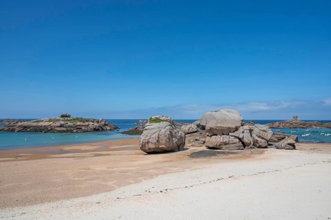 Spectacular pink granite rocks, sculpted by wind and sea, pile up on the beach of the Cote de