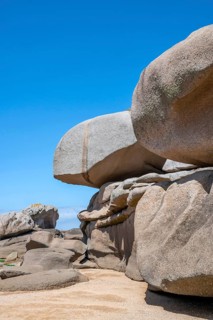 Spectacular pink granite rocks, sculpted by wind and sea, pile up on the beach of the Cote de
