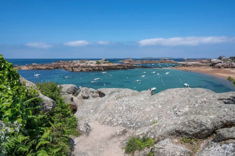 View from the GR 34 coastal hiking trail of the extensive sandy beach of the Plage de la Grève Rose