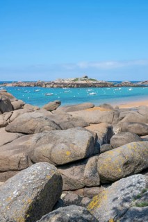 The wide bay of Tregastel on the Cote de Granit Rose shows the turquoise blue sea with white