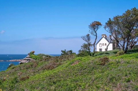 The white Breton house on a green cliff on the GR 34 coastal hiking trail in Trégastel offers a