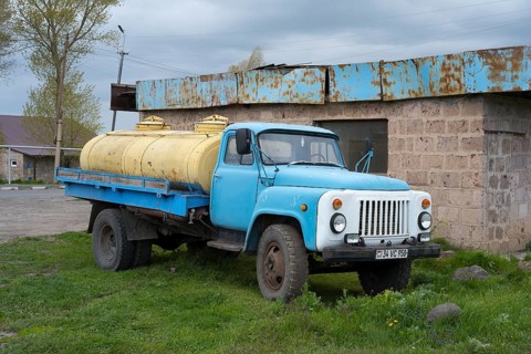 An old blue lorry with yellow tanks stands abandoned in a rural setting, GAZ-53 lorry, tanker,