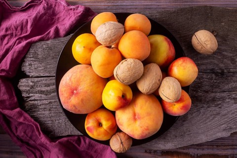 Yellow fruits - peaches, apricots, plums on a wooden background