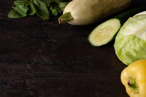 Green vegetables lie on a brown stone