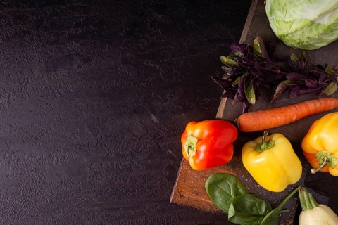 Cabbage, peppers, zucchini, greens, carrots on a wooden board space for text