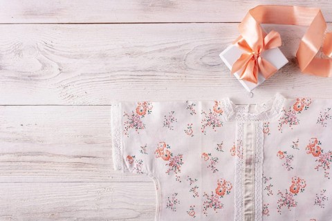 Shirt for newborn toddler and gift box on white wood