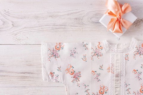 Shirt for newborn toddler and gift box on white wood