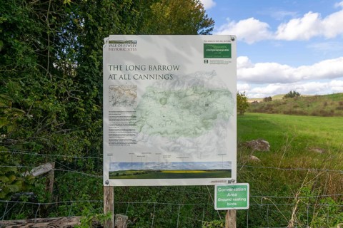 Information notice sign, Modern-day neolithic style long Barrow burial chamber for storing