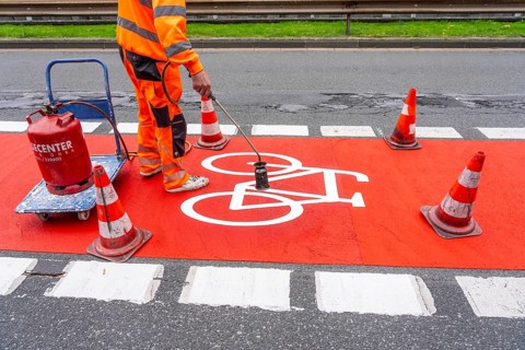Application of red road surfacing on a cycle lane, inner-city road, so-called cold plastic