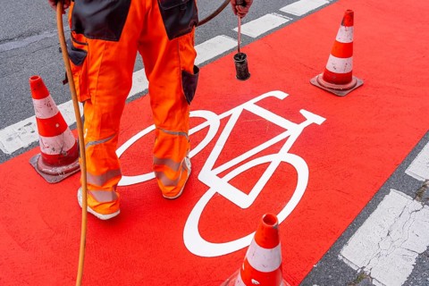 Application of red road surfacing on a cycle lane, inner-city road, so-called cold plastic