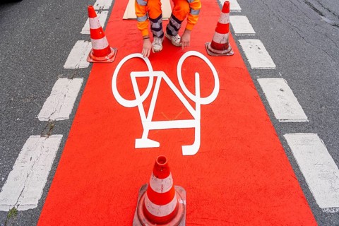Application of red road surfacing on a cycle lane, inner-city road, so-called cold plastic