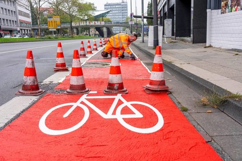 Application of red road surfacing on a cycle lane, inner-city road, so-called cold plastic