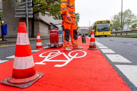Application of red road surfacing on a cycle lane, inner-city road, so-called cold plastic