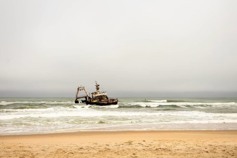 The Zeila shipwreck off Namibia's Skeleton Coast, rusting in the Atlantic surf under cloudy skies