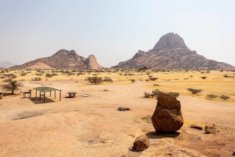 Granite peaks and rugged desert landscape at Spitzkoppe Community Campsite, Namibia. Golden