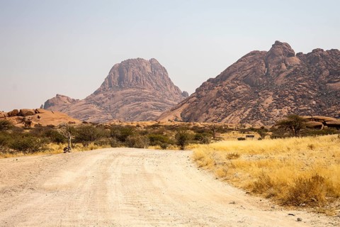 Granite peaks and rugged desert landscape at Spitzkoppe Community Campsite, Namibia. Golden