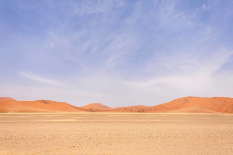 Sossusvlei in Namibia is a desert wonder, famous for its giant red dunes, glowing at sunrise and