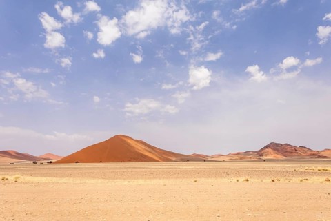 Sossusvlei in Namibia is a desert wonder, famous for its giant red dunes, glowing at sunrise and