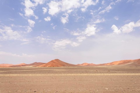 Sossusvlei in Namibia is a desert wonder, famous for its giant red dunes, glowing at sunrise and