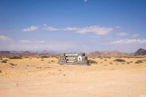 Stone entrance sign of Namib-Naukluft National Park in Namibia- 27 August, 2025: surrounded by