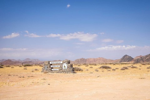 Stone entrance sign of Namib-Naukluft National Park in Namibia- 27 August, 2025: surrounded by