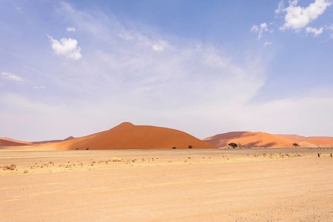 Sossusvlei in Namibia is a desert wonder, famous for its giant red dunes, glowing at sunrise and