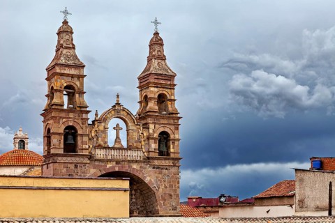 Historic church with imposing spires against a dramatic, cloudy sky, Cathedral spires over the city