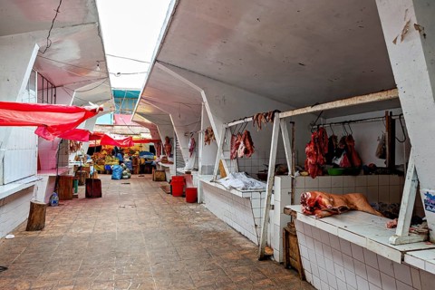 Covered market area with various stalls and an aisle in the centre, The meat market in the market